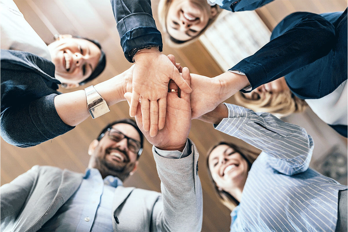 Titelbild Dienstleistung Agile, Evolutionäre Organisationen – Personengruppe legt Hände in die Mitte